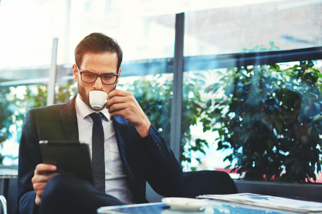 business_man_having_coffee_reading_tablet